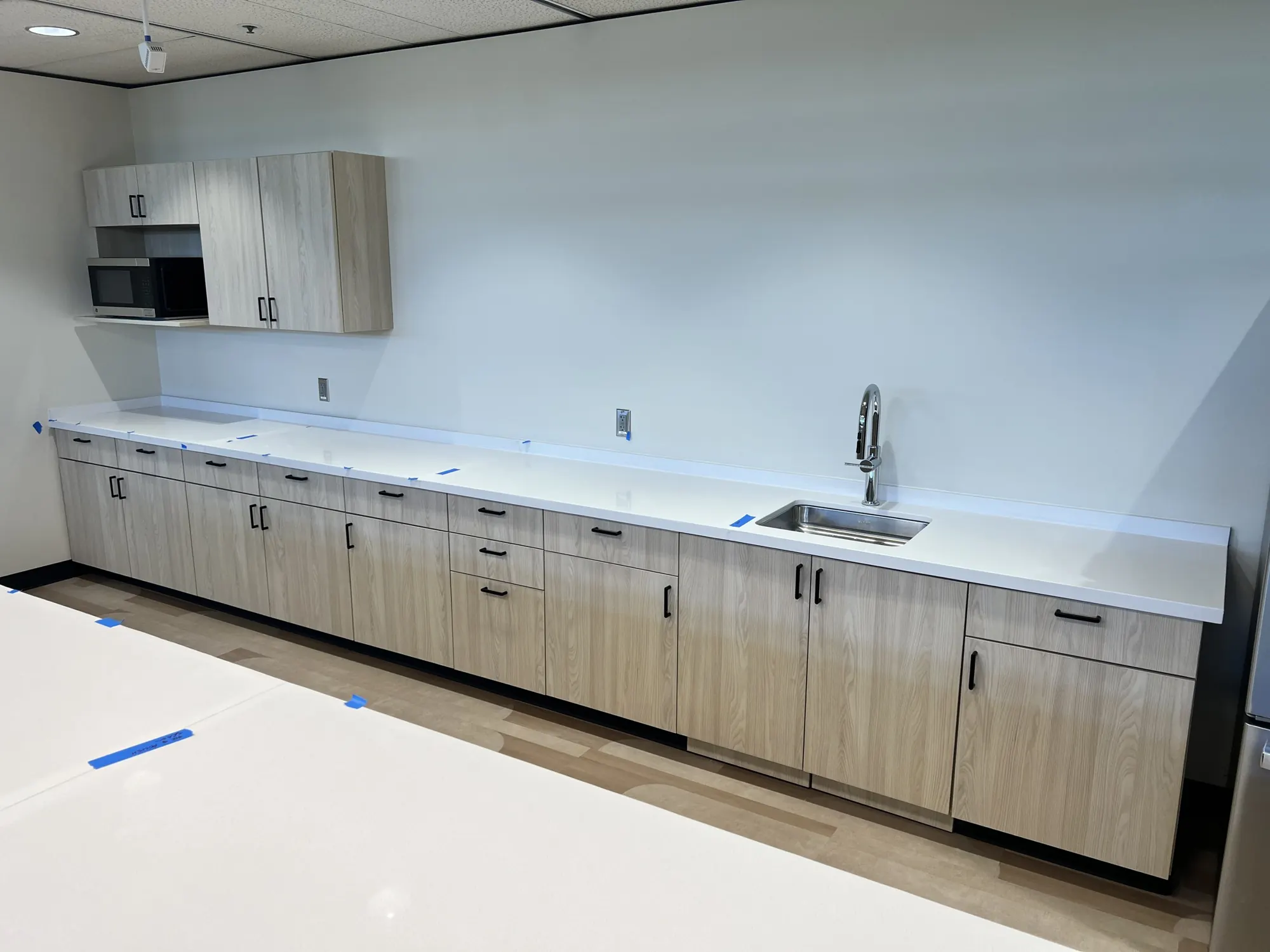 Breakroom with base and upper cabinets and a sink