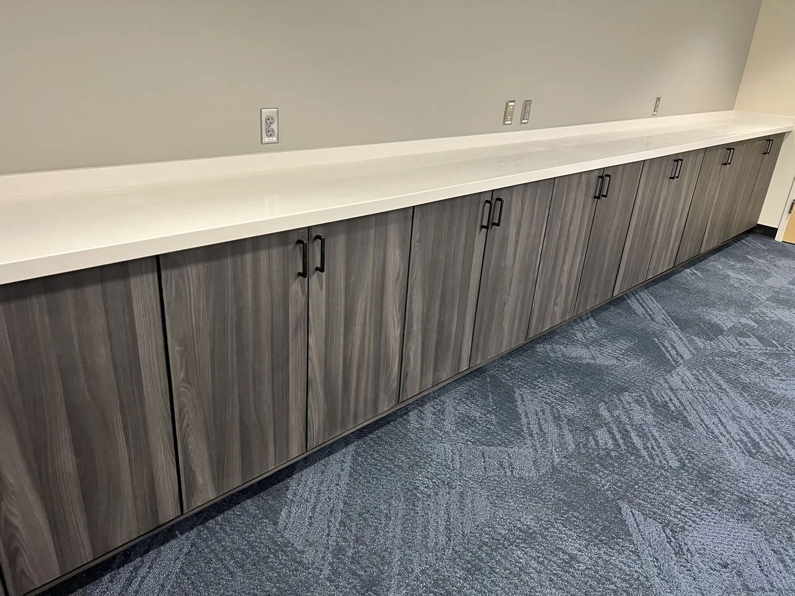 Long run of wood-grain cabinets with a white top