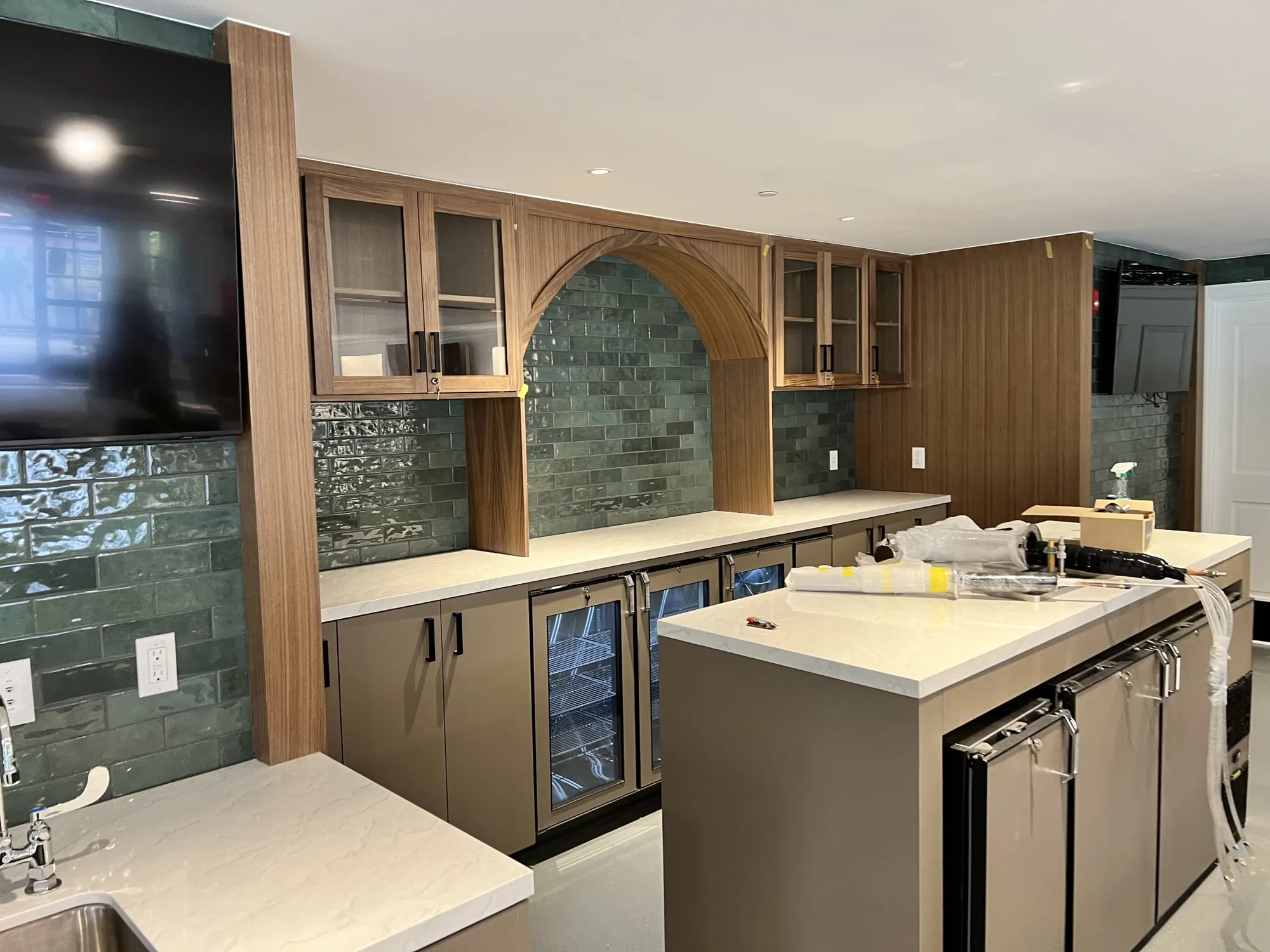 Bar back casework with glass uppers and an arched tile surround