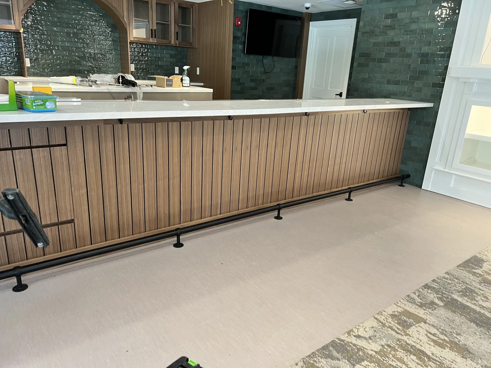 Bar front with vertical wood slats and a foot rail