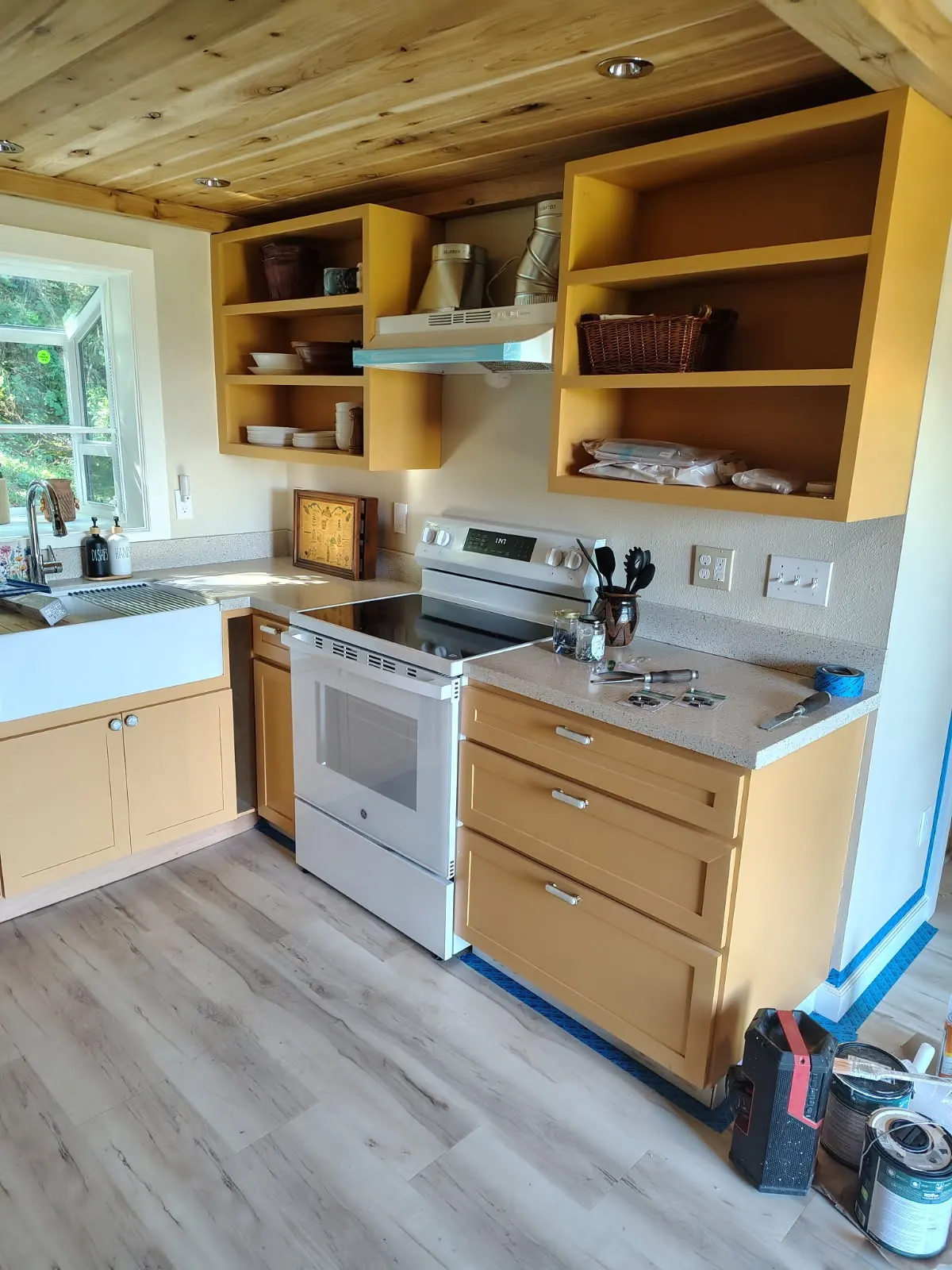 Cabin kitchen with open shelving under a cedar ceiling