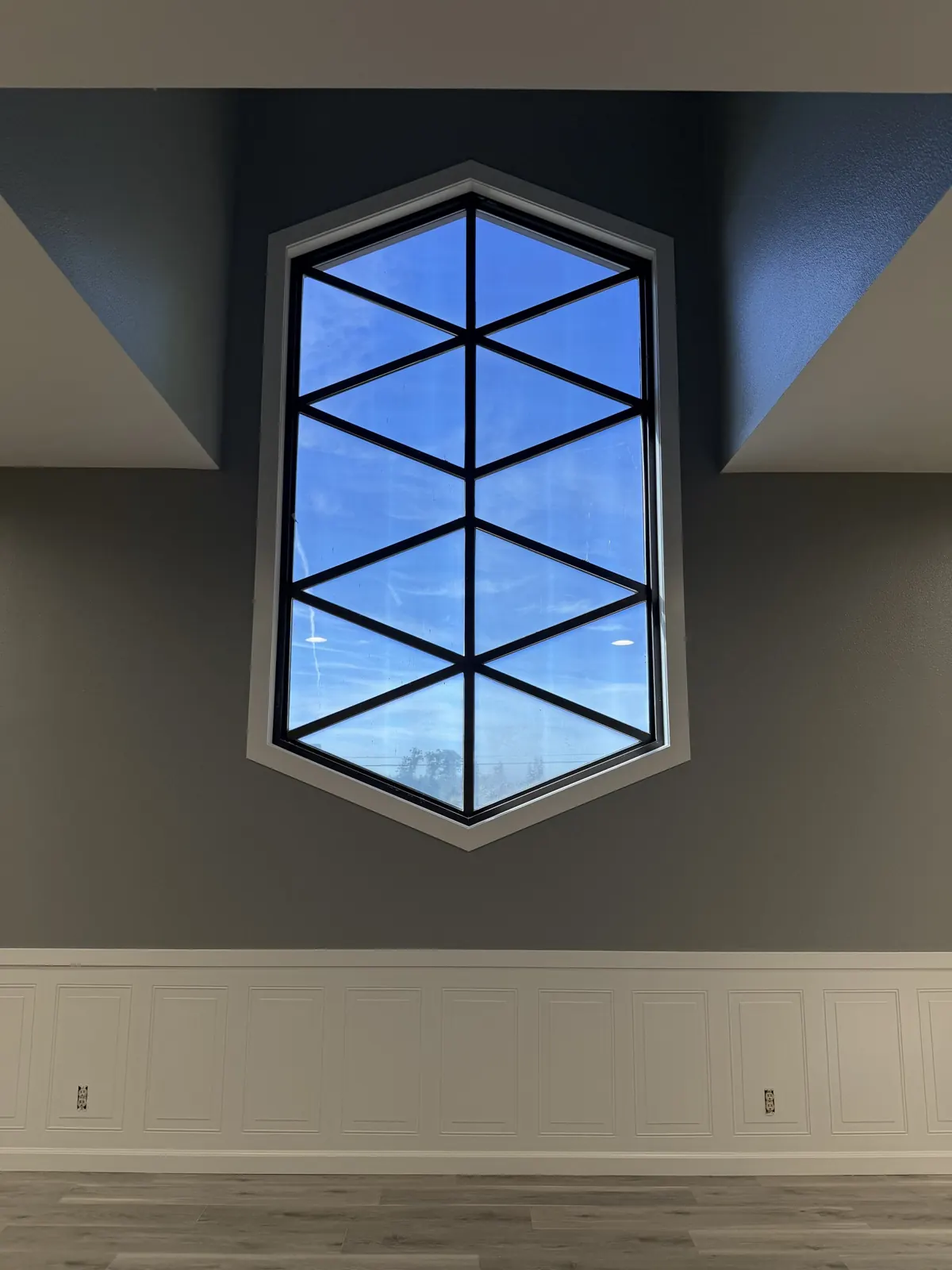 Hexagonal window above painted wainscot